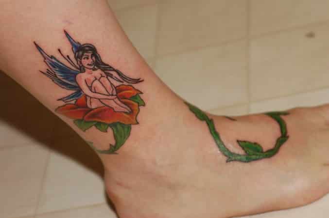 tatuaje a color en parte del pie con ramas verdes